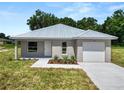 Single story home with gray siding and metal roof at 522 S Perry Ave, Fort Meade, FL 33841