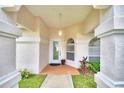 Inviting covered entryway with a white door and decorative plants at 3258 Triple Crown Ln, Lakeland, FL 33811