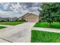 Tan one-story house with a two-car garage at 653 Hidden Lakes Ct, Haines City, FL 33844