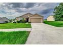 Tan one-story house with a two-car garage at 653 Hidden Lakes Ct, Haines City, FL 33844