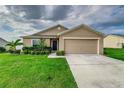 Tan one-story house with a two-car garage at 653 Hidden Lakes Ct, Haines City, FL 33844