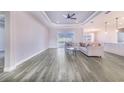 Spacious living room featuring gray wood-look floors, a light-colored sectional sofa, and large windows at 5017 Ridgefield Lane, Lakeland, FL 33812