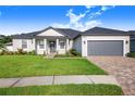 House exterior showcasing a two-car garage, landscaped yard, and a paved driveway at 5017 Ridgefield Lane, Lakeland, FL 33812
