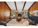 Living room features a stone fireplace and wood paneled walls at 4500 Old Colony Rd, Mulberry, FL 33860