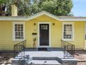 Front view of a charming yellow house with a black door at 714 Winfree Ave, Lakeland, FL 33801
