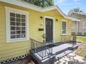 Charming yellow house with a black door, gray walkway, and well-manicured lawn at 714 Winfree Ave, Lakeland, FL 33801