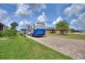 Brick paved driveway with a large RV parked, tall palm trees, and lush lawn at 544 Narrow Pond Rd, Polk City, FL 33868