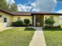 Exterior of single-story home with landscaped lawn and walkway at 180 Lakeview Dr, Haines City, FL 33844