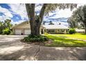 Ranch style home with metal roof, two car garage, and mature landscaping at 310 Willow Oak Ct, Fort Meade, FL 33841