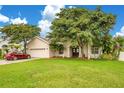 Tan house with a red car parked in the driveway at 2948 Vintage View Cir, Lakeland, FL 33812