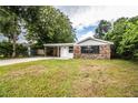 Brick ranch house with carport and large lawn at 415 Lucille St, Bartow, FL 33830