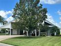 One-story home with carport and lush landscaping at 1045 Caravan Loop, Polk City, FL 33868