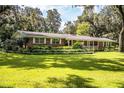Brick ranch house with large yard, mature trees, and ample curb appeal at 7525 Catherine Dr, Lakeland, FL 33810