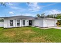 Ranch-style house with a white exterior and modern garage door at 4618 Crestview Ln, Lakeland, FL 33813