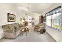 Living room with beige sofa, armchairs, coffee table and carpeted floor at 6205 Raven Run, Lakeland, FL 33809