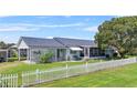Light blue house with a white picket fence and large tree at 13958 Hatchineha Rd, Haines City, FL 33844