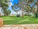 Backyard with lush lawn, water view, and stone patio at 4070 Lake Marianna Dr, Winter Haven, FL 33880