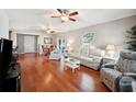 Bright living room with hardwood floors, light colored furniture, and access to backyard at 4829 Colonnades E Cir, Lakeland, FL 33811
