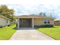Tan one-story house with a covered carport and well-maintained lawn at 608 Lark Dr, Lakeland, FL 33813
