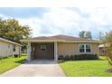 Tan one-story house with a covered carport and well-maintained lawn at 608 Lark Dr, Lakeland, FL 33813