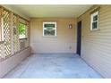 Covered front porch with concrete flooring and wooden lattice at 608 Lark Dr, Lakeland, FL 33813