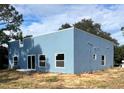 Blue house showcasing rear elevation with modern design and large windows at 2626 Magnolia Cir, Lake Wales, FL 33898