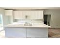 Modern kitchen featuring white cabinets, quartz countertops, and a large island at 2626 Magnolia Cir, Lake Wales, FL 33898