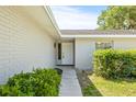 Inviting front entrance with walkway, landscaping, and a freshly painted white brick exterior at 2233 20Th Nw St, Winter Haven, FL 33881