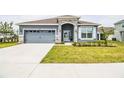 New home exterior with gray siding, stone accents, and a two-car garage at 731 Griffon Ave, Lake Alfred, FL 33850