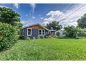 Backyard view of renovated home with large lawn at 315 Keat Ave, Auburndale, FL 33823