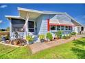 Quaint mobile home exterior with covered porch and colorful landscaping at 5002 Lodgewood Dr, Lakeland, FL 33810