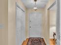 Bright entryway with hardwood floors, double closets, and a view of the living area at 1175 E George St, Bartow, FL 33830