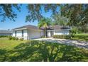 White one-story house with a two-car garage and driveway at 941 Devonshire Way, Lake Wales, FL 33853