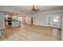 Open living room with light walls, hardwood floors, and access to the kitchen at 300 Winona Ct, Auburndale, FL 33823
