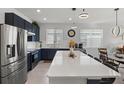 Modern kitchen with navy blue cabinets, white countertops, and stainless steel appliances at 7488 Ibis Dr, Lakeland, FL 33810