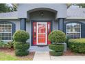 Red front door entrance with flanking shrubs at 3120 Ne 26Th St, Ocala, FL 34470