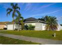 House exterior with a two-car garage and well-manicured lawn at 1015 Highland Crest Cir, Lake Wales, FL 33853