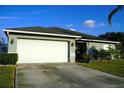 Exterior view of a house with a white garage door and landscaping at 1015 Highland Crest Cir, Lake Wales, FL 33853