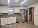 Updated kitchen with white cabinets, stainless steel appliances, and tile flooring at 1744 Quail Hill Dr, Lakeland, FL 33810