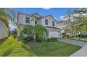 Two-story house with white exterior, palm tree, and landscaped lawn at 1568 Maidstone Ct, Davenport, FL 33896