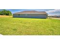Large grassy backyard of a tan house at 1213 Tagliamento Ln, Haines City, FL 33844