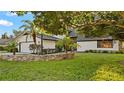 House exterior showcasing stone wall and lush landscaping at 1215 Cypress E Pt, Winter Haven, FL 33884