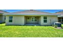 Covered back patio with grassy backyard at 515 Tanaro Ln, Haines City, FL 33844