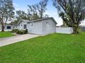 Side view of the house showcasing the gray siding and a white fence at 5225 Golden Gate Blvd, Polk City, FL 33868