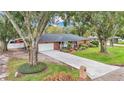 Brick house with a large front yard and long driveway, surrounded by mature trees at 4264 Stafford Dr, Winter Haven, FL 33880