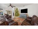 Living room featuring leather sofas, a large TV, and a Christmas tree at 1849 Charleston Ln, Bartow, FL 33830