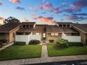 Tan two-story condo building with grassy landscaping and walkways at sunset at 5225 Imperial Lakes Blvd # 22, Mulberry, FL 33860