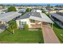 Aerial view of a single-wide manufactured home with carport and well-maintained lawn at 6461 Hollyberry Ne Ln, Winter Haven, FL 33881