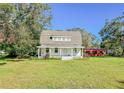 Farmhouse exterior with a large yard and mature trees at 285 Lemon St, Mulberry, FL 33860