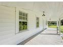 Bright, spacious front porch with white railings and wood flooring at 285 Lemon St, Mulberry, FL 33860